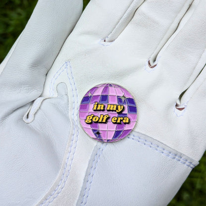 purple mirrorball golf ball marker that says 'in my golf era' in glove