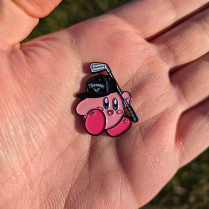 golf ball marker shaped like pink super smash character holding a golf club in hand