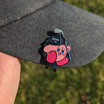 golf ball marker shaped like pink super smash character holding a golf club clipped on a hat